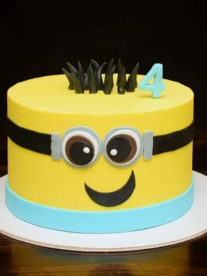 A fun Minion cake for a fourth birthday celebration. I used mostly buttercream to get those crisp, clean edges, with just a few fondant details for the eyes and smile. It's a cheerful and instantly recognizable design.