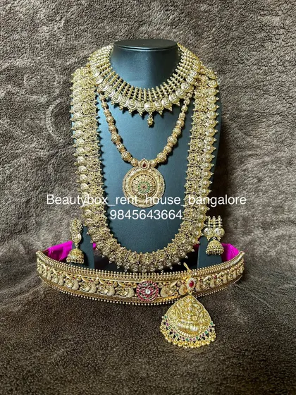A beautiful antique coin (kasu) necklace set, including a choker, a long kasu haram, and a matching vaddanam. A very popular rental for its traditional appeal.