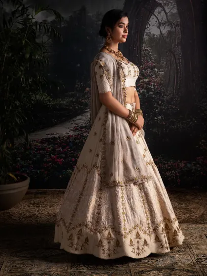 A side profile of the Moonga Silk lehenga, highlighting its graceful silhouette and the delicate brocade touches that add a layer of understated opulence.