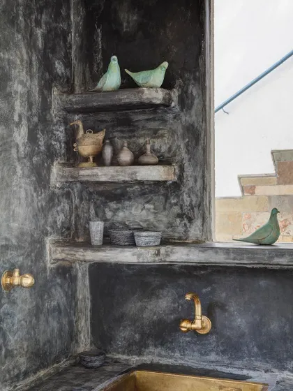 Handcrafted details in a bathroom at Jalakara, featuring a brass sink and decorative objects sourced from across India.