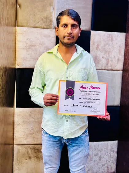 Another successful student, Rakesh, proudly holds his certificate of completion. We welcome students from all walks of life to join our professional beauty courses.