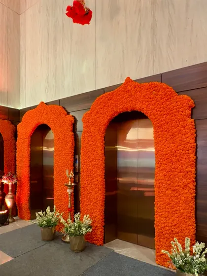 Even functional spaces like elevators can be transformed into beautiful decor elements. Here, I framed the elevator doors with arches made entirely of vibrant orange marigolds, turning a simple entryway into a festive photo opportunity.
