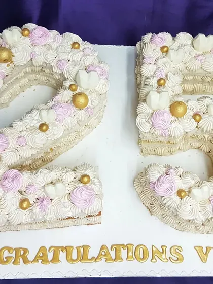 A beautiful number cake to celebrate a 25th anniversary or birthday. This "25" is decorated with delicate buttercream swirls, flowers, and golden pearls for an elegant and personalized touch.