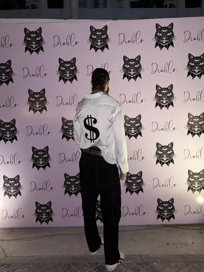 Posing for a photo, this client shows off the back of his made-to-order shirt. I work with you to create designs that are not just clothes, but conversation starters.