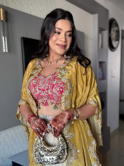 A stylish indo-western look perfect for a Mehendi, with a pink embroidered top and a mustard yellow cape.