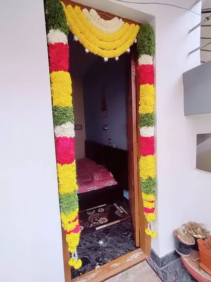 A simple door decoration using colorful flower garlands. This is a cost-effective way to add a festive touch to your home for any celebration.