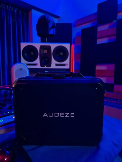 The Audeze MM-500s come in a rugged travel case, which is perfect for remote work. In the background, you can see my main studio monitors and some of the acoustic treatment that ensures my room is a reliable listening environment.