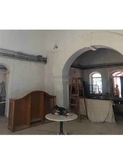 The main hall during construction, with its grand archway being prepared for plastering. This image captures the raw state of the interior, highlighting the structural forms that we work to enhance and preserve.
