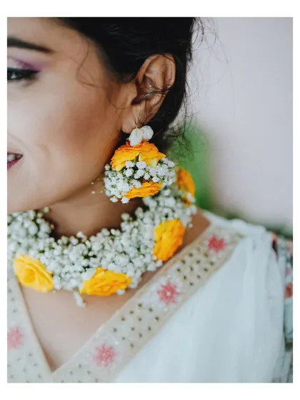A close-up shot of the bride's exquisite floral jewelry, a popular trend for modern Haldi ceremonies.