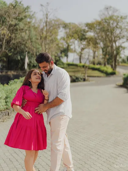 A sweet and candid walking shot through a park, capturing a natural, loving interaction between the couple.