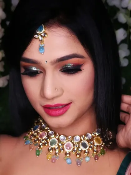 A close up of the dramatic eye makeup from a creative shoot, featuring a blend of warm tones and a pop of green glitter.