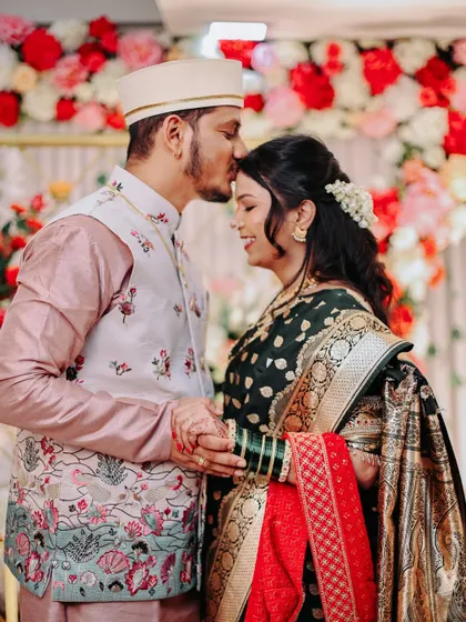 A tender moment from an engagement ceremony, with the groom kissing the bride's forehead.