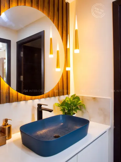 A closer look at the stylish wash counter, highlighting the contrast between the dark blue sink, black faucet, and the warm tones of the wooden panel and pendant lights.