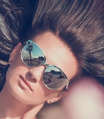 A creative close-up where the reflection in the sunglasses tells a story. This shot is playful and clever, showing attention to detail and a unique perspective on fashion photography.