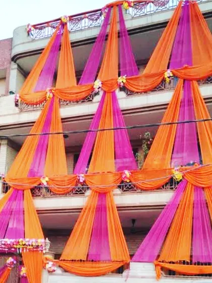 An intricate draping design on a house facade using orange and pink fabric for a grand statement.