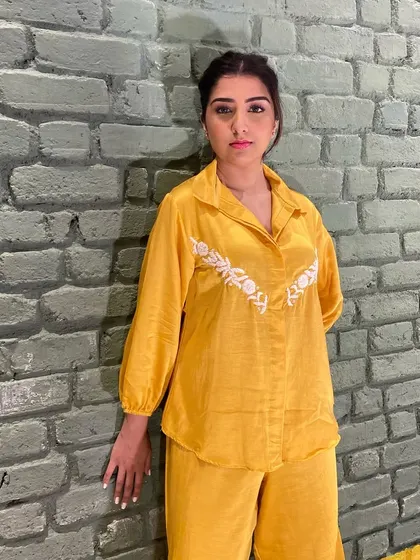 A still from the Beehive Kunjal shoot. This look features a clean, braided hairstyle and subtle makeup to complement the bright yellow outfit.
