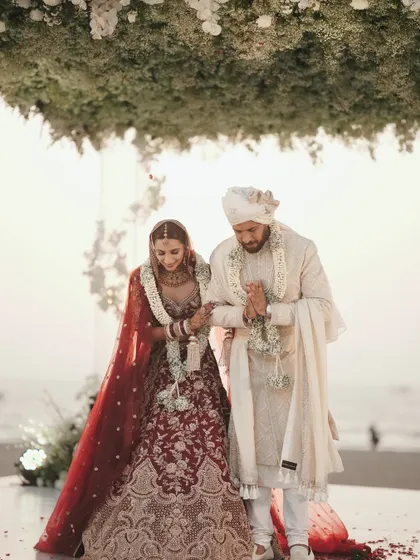 A classic shot of the couple walking together after their wedding ceremony, with the beautiful Goa sea in the background.