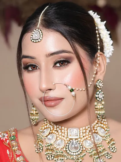 Student work on her portfolio day. This look features a classic red lehenga, a simple bun with gajra, and a beautiful smokey eye.