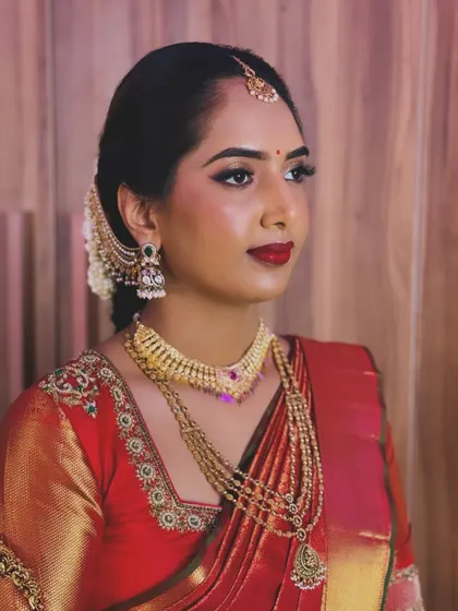 A side profile of Rutuja's classic bridal look, highlighting the clean lines of her makeup and the traditional gold jewellery.