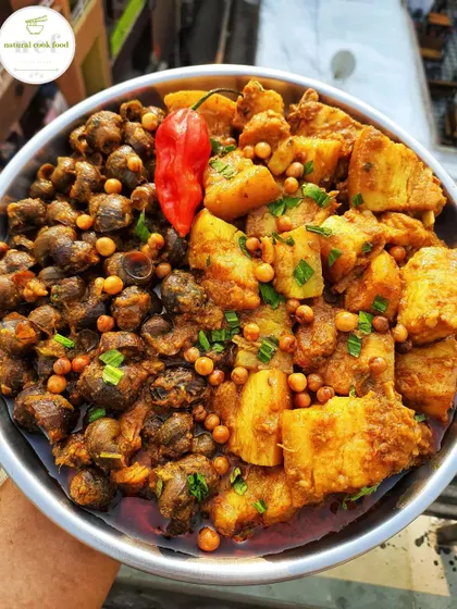 An adventurous and traditional Manipuri dish: pork cooked with snails ('tharoi'). The combination of flavors and textures is truly unique.