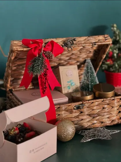 Share the magic of the holidays with our Christmas hamper. This festive wicker trunk is filled with yummy, healthy treats and decorated with a bright red ribbon.