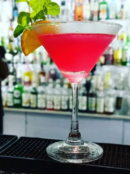 A vibrant pink Cosmopolitan, perfectly chilled and served in a martini glass. This classic cocktail adds a touch of elegance to any celebration.