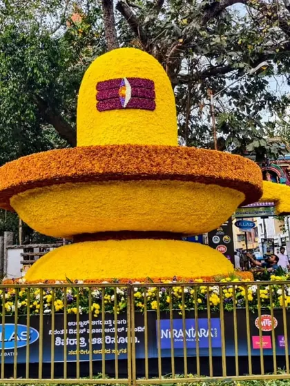 A massive Shivalingam made entirely of yellow and orange flowers for a public flower show.