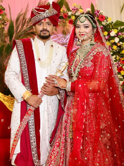 The complete royal couple. The bride's radiant HD makeup and traditional red attire stand out, making for a picture-perfect wedding portrait.