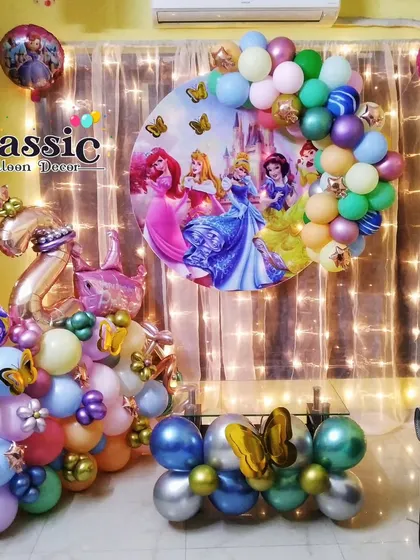 A cozy princess-themed home party setup with a character backdrop, fairy lights, and a colorful balloon arrangement.