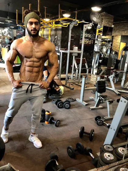 A candid shot in the gym, showing a well-developed core and overall lean muscle mass. This is the result of making fitness a lifestyle, not a chore.