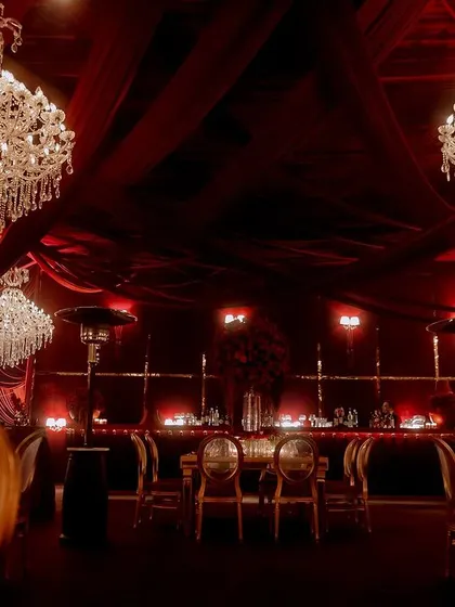 The entire event space was a vision in red, with massive crystal chandeliers hanging from a ceiling of draped fabric. The consistent color scheme and lighting created a powerful, immersive experience.