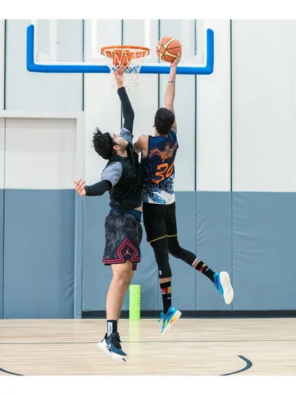 "If you set your goals ridiculously high and it's a failure, you will fail above everyone else's success." This image of a contested layup captures that spirit of aiming high.