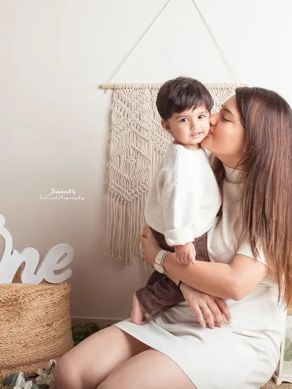 A sweet kiss from mom during a first birthday shoot. These are the tender moments that make the celebration even more special.