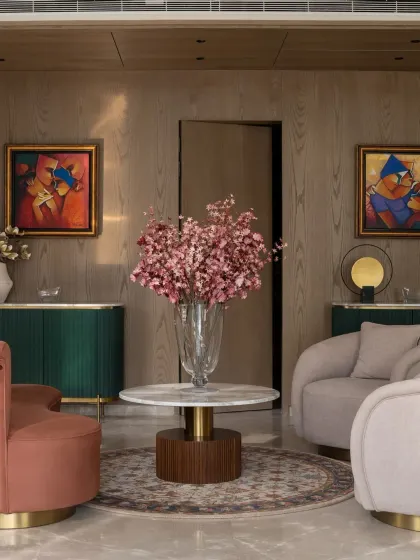 The entrance foyer of the Bhasin home, where curved furniture in terracotta and blush tones, a deep green console, and vibrant art create a warm and welcoming first impression.
