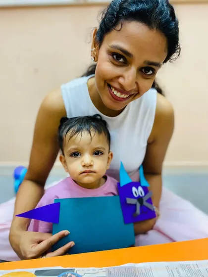 This smiling mother and her child show their finished craft, capturing the sense of pride and connection our program fosters.