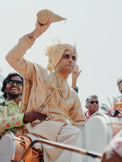 The groom arrives in style, dancing on a dhol drum, bringing incredible energy to the celebration.