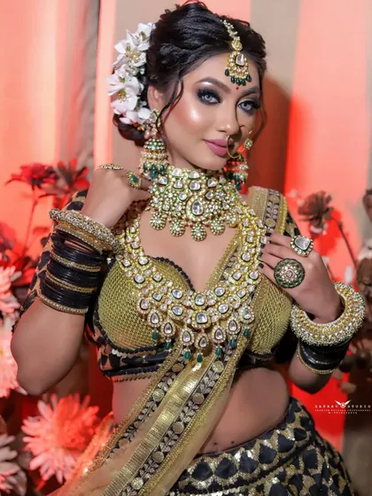 A beautiful three-quarter shot that captures the bride's complete look. The floral background and warm lighting create a rich and celebratory atmosphere.