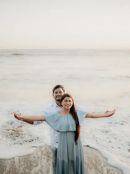 A fun, "Titanic" style pose on the beach with the ocean in the background.