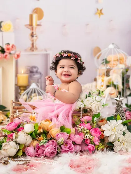 A dreamy floral portrait. This little girl, surrounded by soft pink flowers and pearls, looks like she's in a fairy tale.