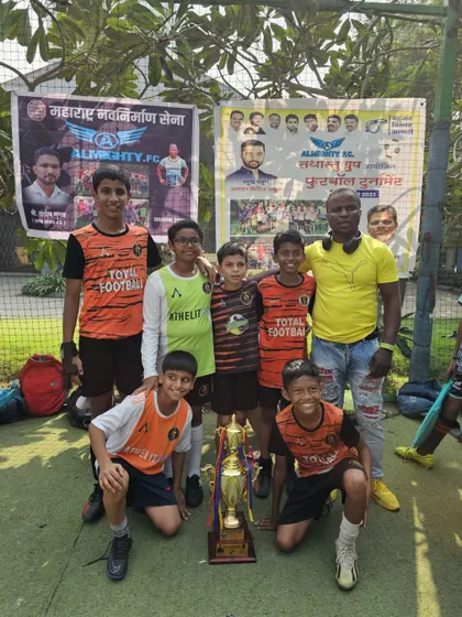 The U13 championship team posing with their coach at the Almighty FC tournament.