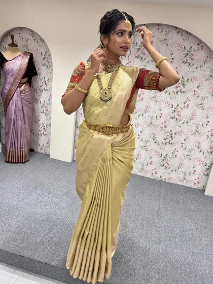A full length view of a classic South Indian look. The golden saree, temple jewellery, and traditional hairstyle create a timeless and elegant appearance.