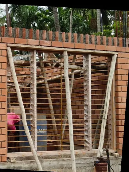 A window opening within an exposed brick wall during the construction phase.