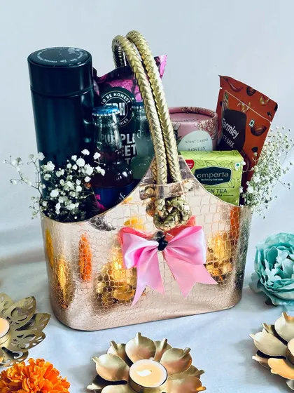 Another view of the rose gold hamper, surrounded by lit diyas to create a festive atmosphere.