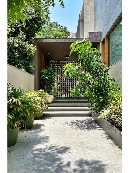 The arrival at the House of Terraces is a carefully choreographed experience. I designed this layered entry sequence with a sculpted screen and lush planters to soften the threshold, creating a gentle transition from the outside world into the private, tranquil spaces within.