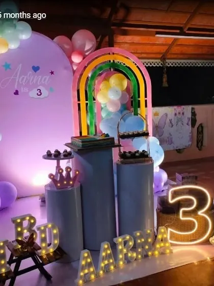 A rainbow-themed party with a large personalized backdrop, marquee letters, and a colorful balloon arrangement.
