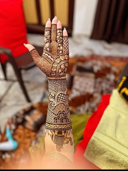 A side view of a full bridal arm, showing how the design flows from the palm to the elbow. This one features a doli scene at the bottom.