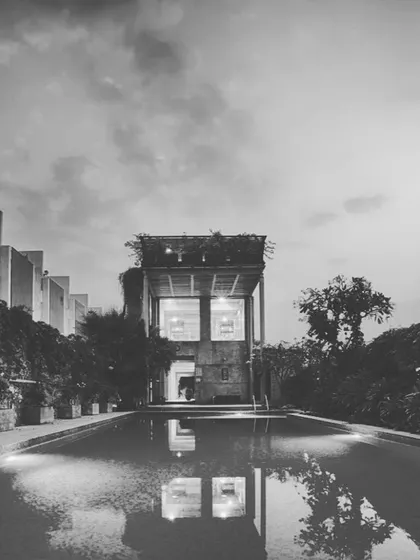 The reflection of the clubhouse in the still water of the ELEVANA pool at dusk, emphasizing the project's focus on creating serene and aesthetically pleasing common areas.
