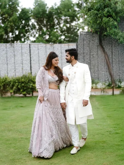 A serene walk in the garden. This portrait captures the couple in a quiet moment, showcasing their elegant coordinated outfits.