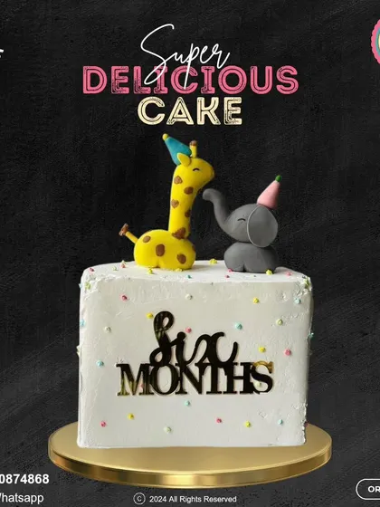 An adorable six-month celebration cake featuring a giraffe and an elephant wearing party hats. The simple, clean design with a "Six Months" plaque is both cute and stylish.