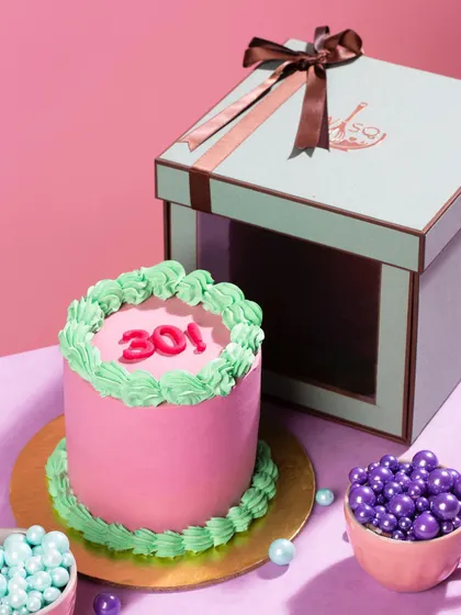 Our pop-coloured mini cakes come in our signature gift boxes, making them a complete and adorable gift. This pink and green cake was customized with the number "301" for a special occasion.